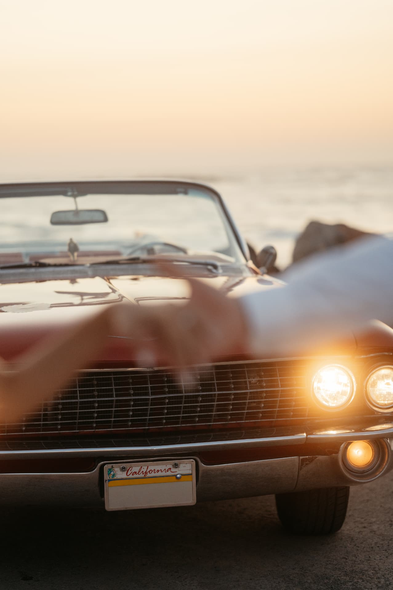 A red vintage Cadillac parked by the sea