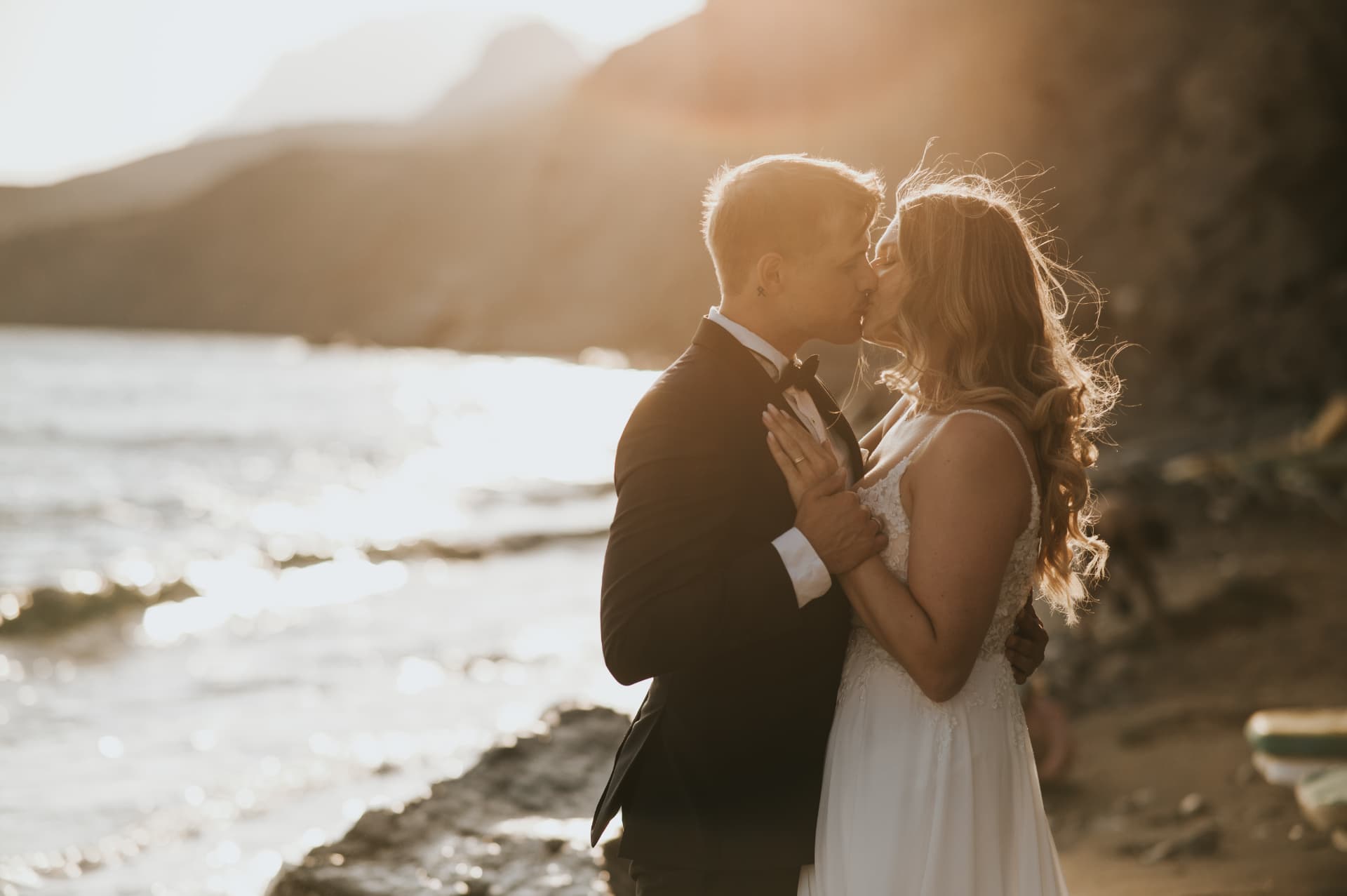 A couple kissing by the sea at sunset